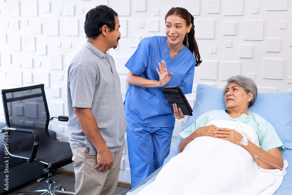 Relatives husband visiting wife lady and talking with nurse on treatment condition at hospital stay Relatives husband visiting wife lady and talking with nurse on treatment condition at hospital stay