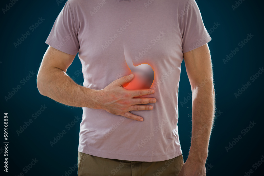 The man standing on a dark background. Picture of a human digestive