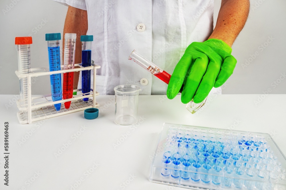 A scientist doctor pouring red fluid blood from a test tube into a beaker A scientist doctor pouring red fluid blood from a test tube into a beaker