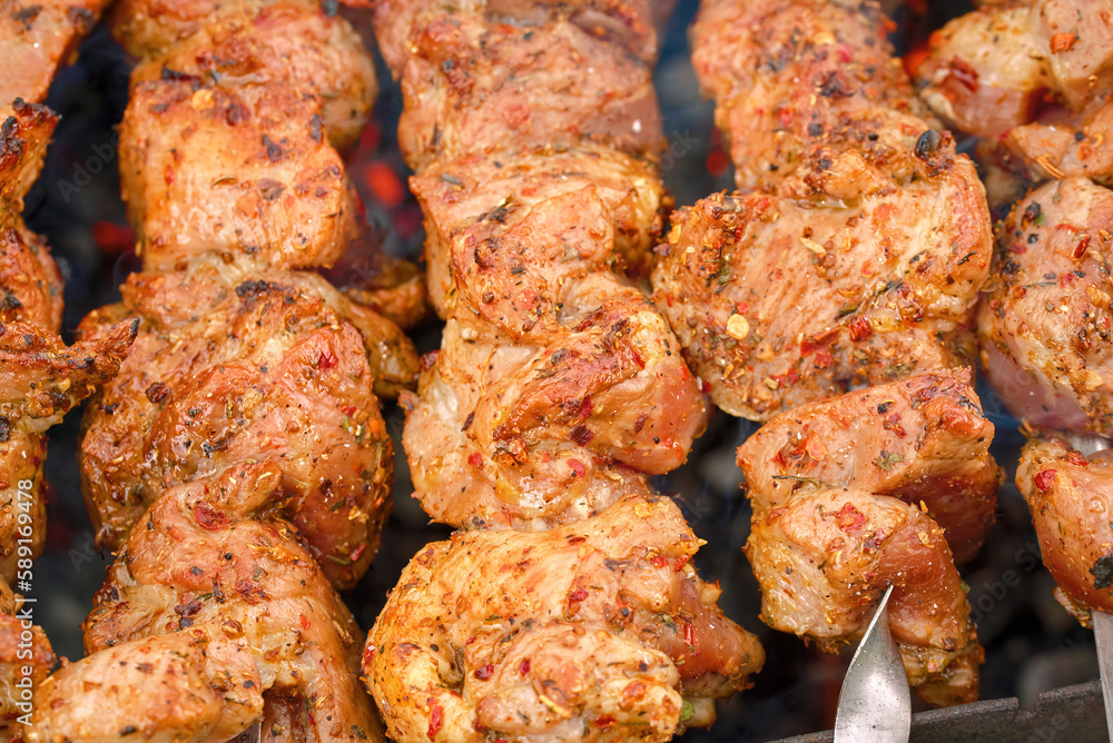 Grill barbecue meat on brazier with smoke. Cooking meat on brazier. Meat sticks cooked at barbecue, close up. Shish kebab cooking outdoors.. Grill barbecue meat on brazier with smoke. Cooking meat on brazier. Meat sticks cooked at barbecue, close up. Shish kebab cooking outdoors..