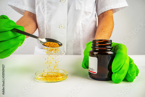 The scientist doctor pours the crystals from the vial onto the dish
