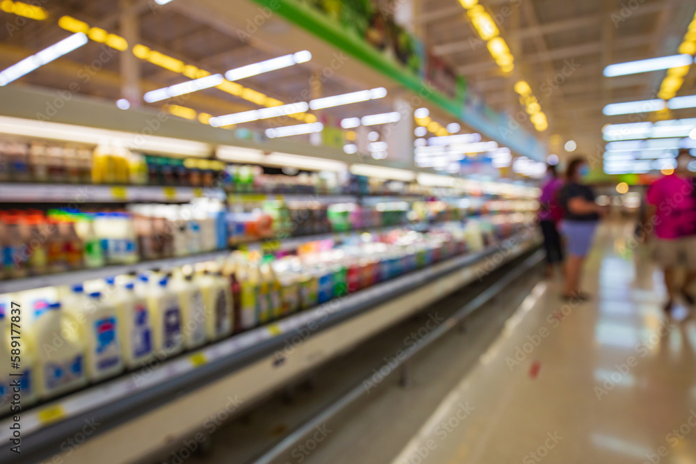 Defocused blur buying milk put on shelf in supermarket Defocused blur buying milk put on shelf in supermarket