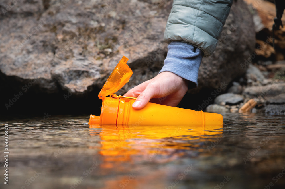 Closeup of female hands pouring drinking water from a mountain spring