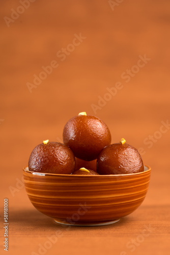 Gulab Jamun in bowl on wooden background. Indian Dessert or Sweet Dish.