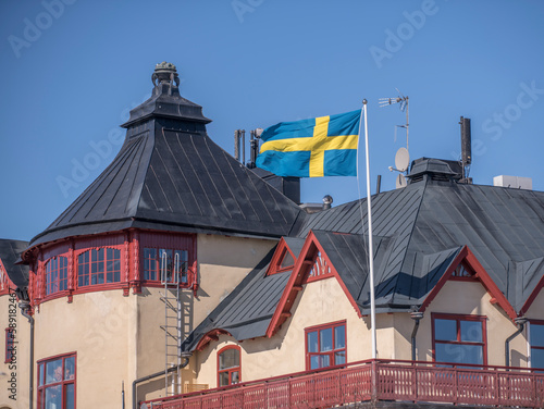 Black tin roofs and Swedish flag on the famous hotel in the archipelago Vaxholm, a sunny spring day in Stockholm