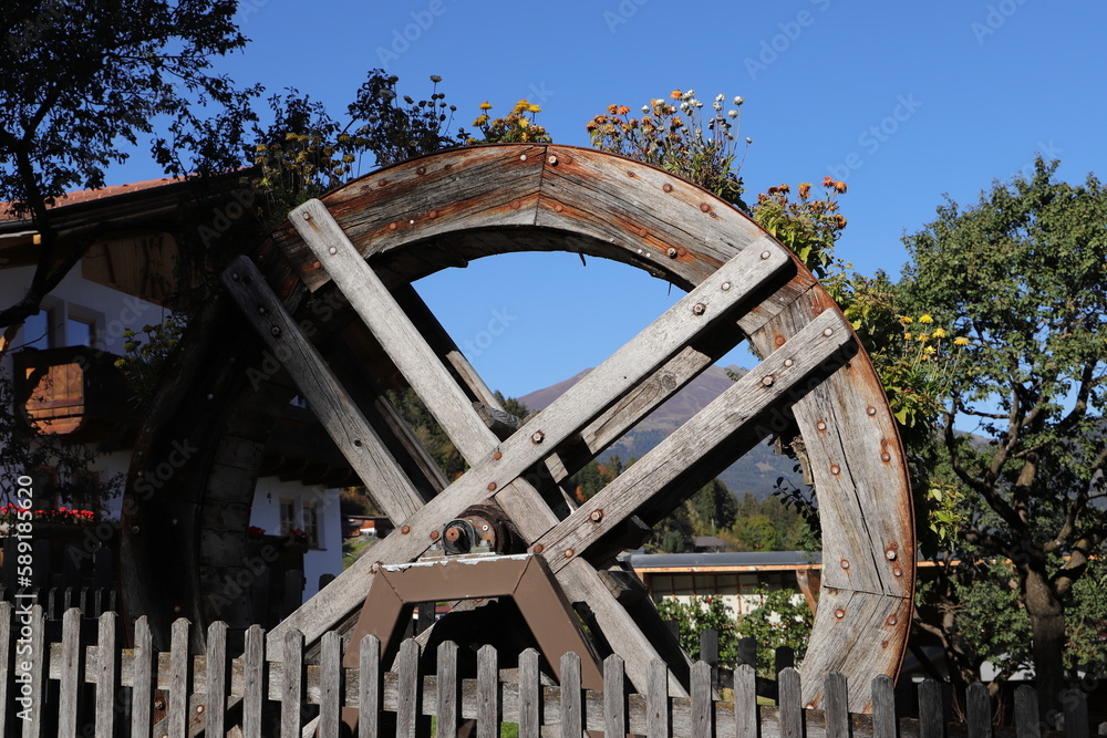 an old water wheel as decoration with flowers