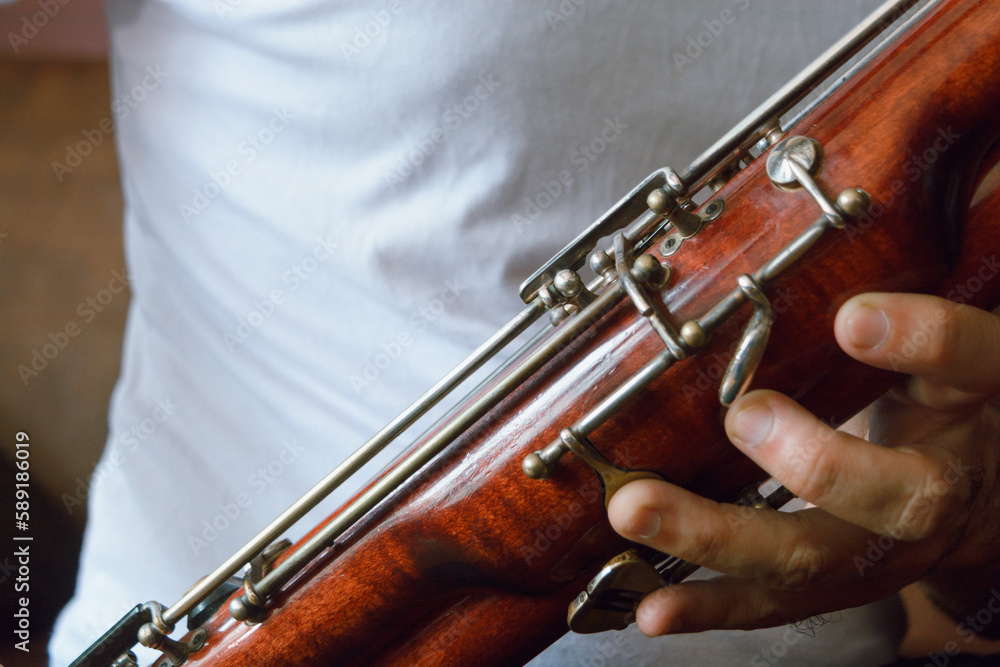 Fototapeta premium close-up of male hands playing the bassoon, copy space