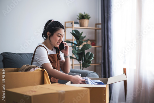 New house, asian woman put the stuff in the box while feeling proud and excited about buying a house with a mortgage loan. Young asian woman first time buyers unpacking in dream home or apartment