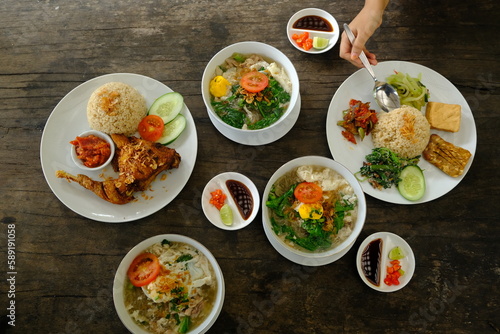 ayam goreng, mie lethek, nasi campur, kecap, sambal, acar. Indonesian dishes on a rustic wooden table. top view. Indonesian food.