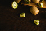 Sweet fruit on a dark background. Small pieces of kiwi on a wooden background