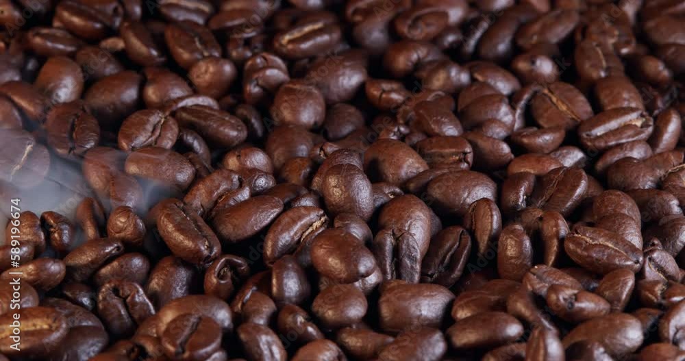 Fragrant coffee beans are roasted in a frying pan, smoke comes from coffee beans. The whole composition scrolls slowly around the camera. Fragrant coffee beans are roasted in a frying pan, smoke comes from coffee beans. The whole composition scrolls slowly around the camera.