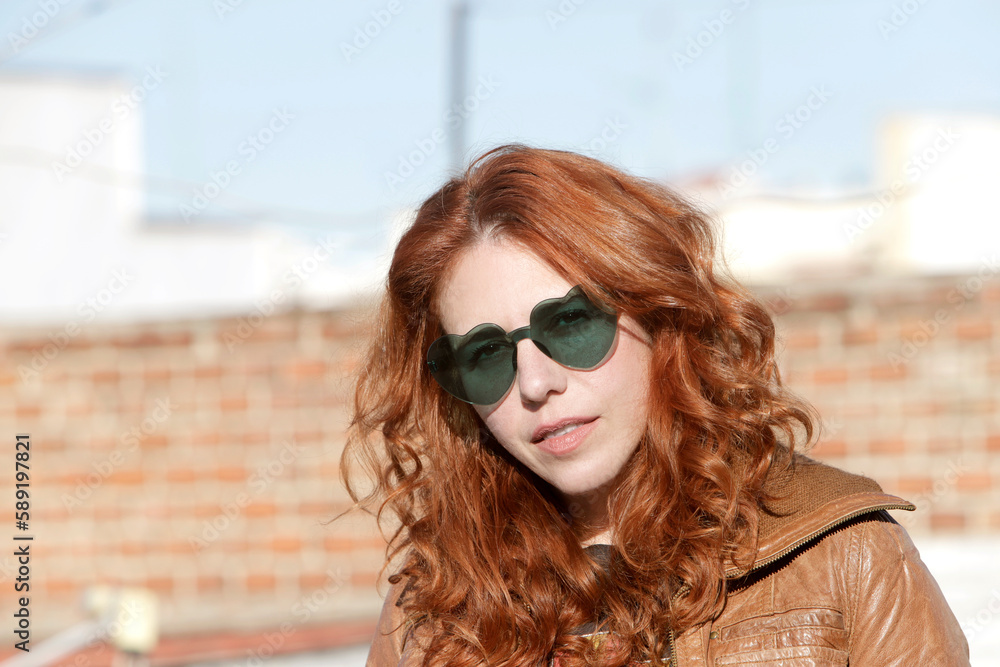 woman with heart-shaped glasses looking at camera on location woman with heart-shaped glasses looking at camera on location