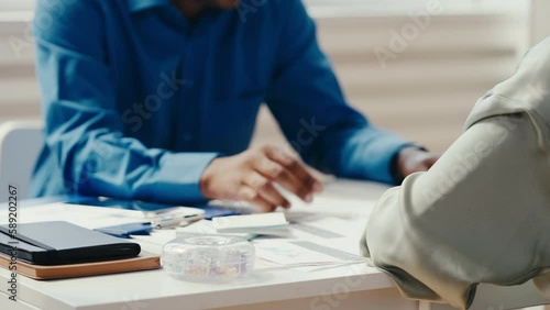African American male interviewer talking with job candidate, gesturing hands
