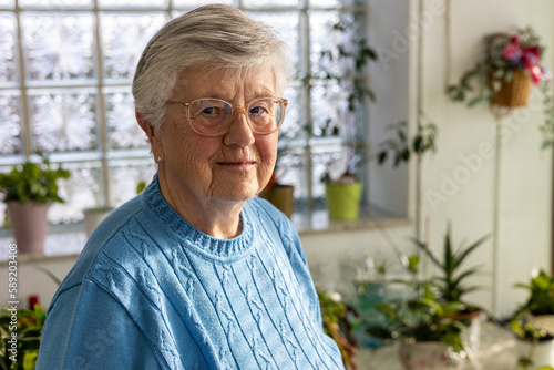 Portrait of 85 years old senior woman in winter garden 