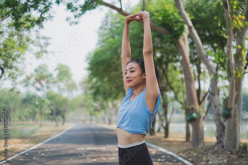 Young woman working out in early morning, practicing exercise, doing stretching out before running or jogging. Concept of healthy life, relaxation ,recreation. City life style. Body movement. warm up © Irin