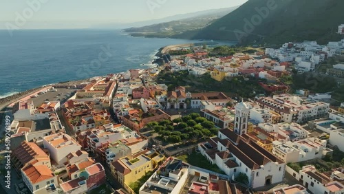 Flying over Garachico city center with colored houses. Aerial view of Old town of Garachico on island of Tenerife, Canary. Ocean shore and lava pools. Popular tourist destination, pearl of the Canary photo