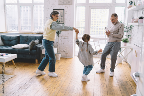 Positive family dancing in living room at home © BullRun