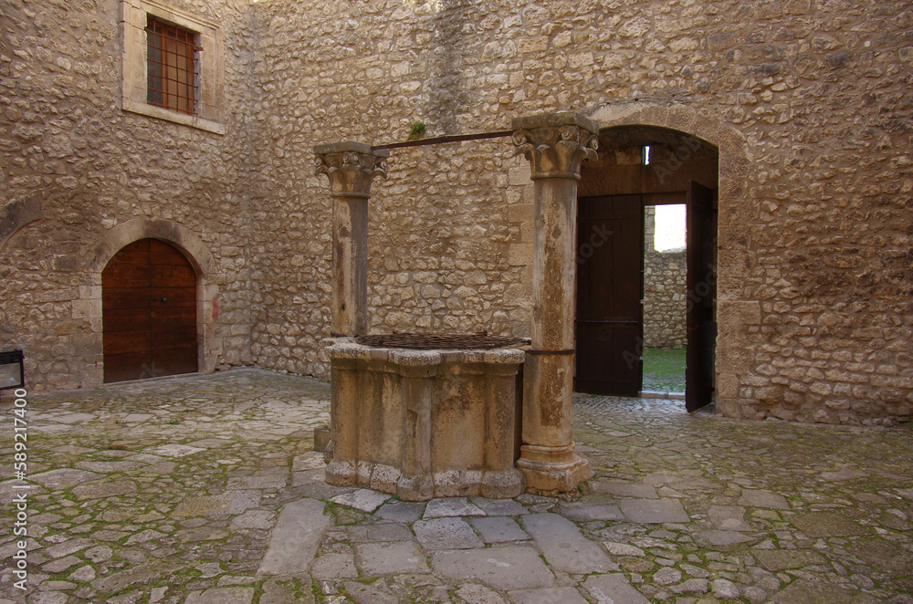 Obraz premium Piccolomini Castle of Capestrano (AQ - 15th-century marble well, flanked by columns with foliate capitals.