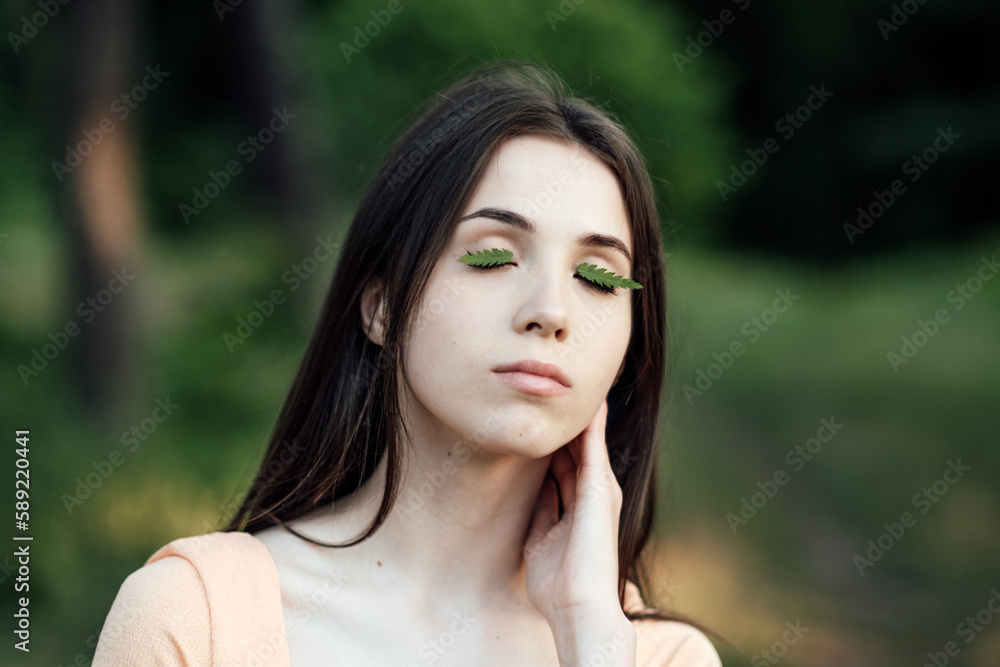 Celebrate Earth Month, Earth Day. Spend time in nature. Connect to nature is way to mitigate climate anxiety. Young woman, girl outdoors portrait on green nature background Celebrate Earth Month, Earth Day. Spend time in nature. Connect to nature is way to mitigate climate anxiety. Young woman, girl outdoors portrait on green nature background