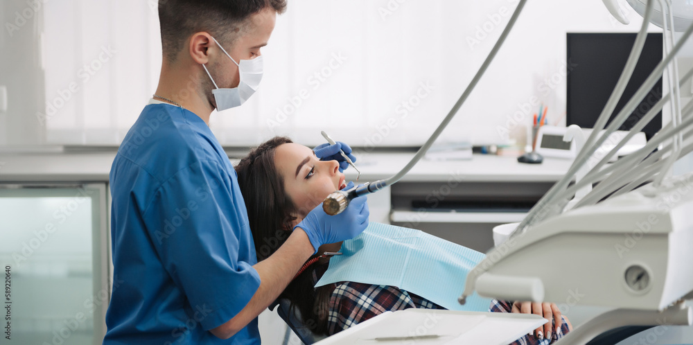 Obraz premium Dentist treats teeth of patient