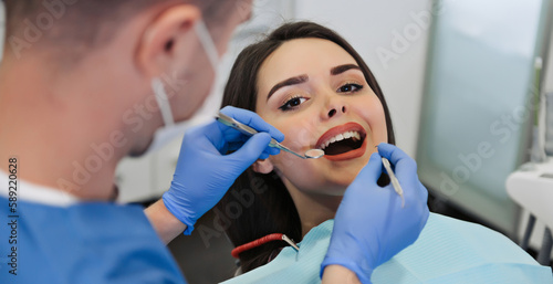 close up view of dentist treating teeth of girl in dentist office