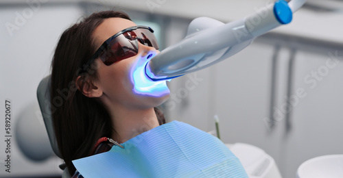 Teeth whitening for woman. Bleaching of the teeth at dentist clinic. photo