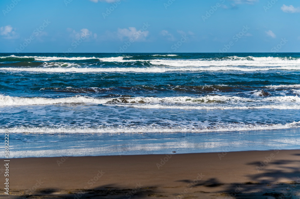 A view down the beach towards waves breaking at Tortuguero in Costa Rica during the dry season