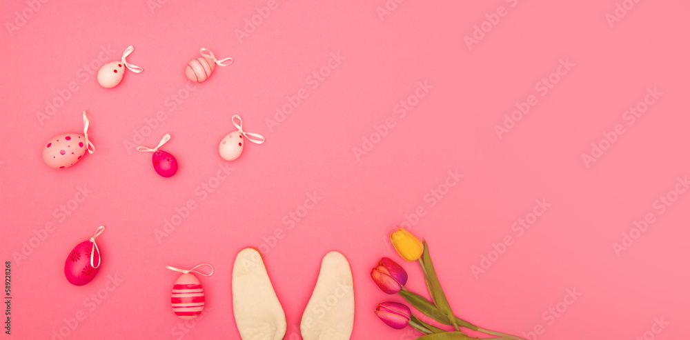 Pink background with Easter eggs, bunny ears and flowers offers plenty of room for copying