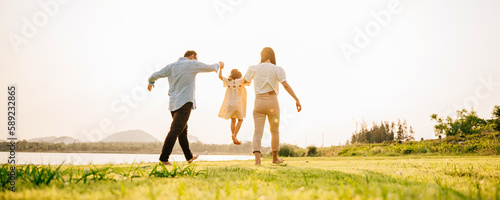 Foto Back view of Happy Asian family walking and playing together in a scenic garden,