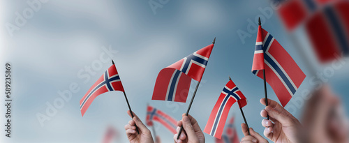 Photography A group of people holding small flags of the Norway in their hands