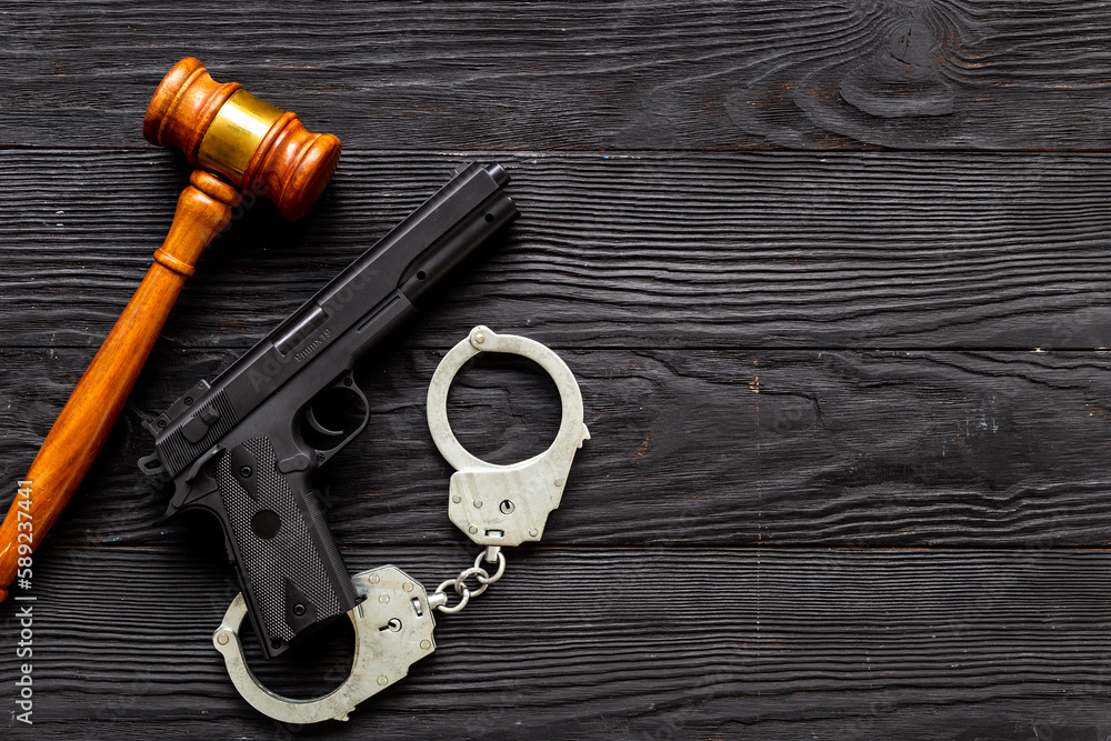 Hand gun weapon with handcuffs - illegal use of weapons concept Hand gun weapon with handcuffs - illegal use of weapons concept