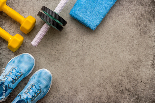 Sneakers and dumbbells for workout sport flatlay background