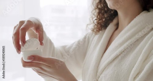 Wallpaper Mural Beauty lady with treatment moisturizing body care, health and wellness concept. Hygiene and skin care concept. Young woman holding in her hands and opening a bottle with facial cream Torontodigital.ca