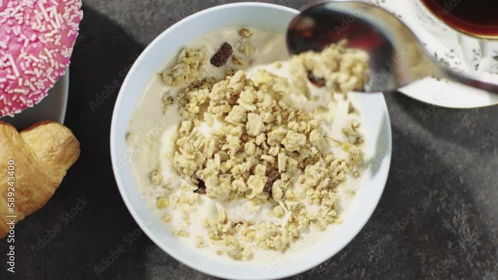 Pouring muesli into a cereal bowl for breakfast. A beautiful morning composition of fruits and healthy food. High quality 4k footage Pouring muesli into a cereal bowl for breakfast. A beautiful morning composition of fruits and healthy food. High quality 4k footage