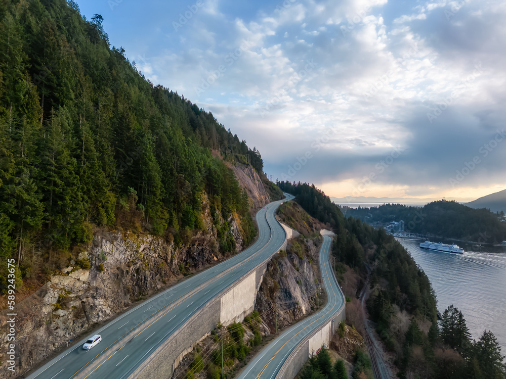 Obraz premium Aerial View of Sea to Sky Highway in Howe Sound. Sunset Sky. Between Squamish and Vancouver, BC, Canada.