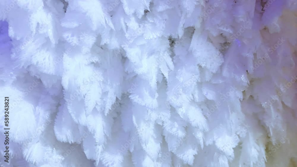 Excursion to the dark ice cave in winter. A cave with icicles and ice. Tourism in Russia, the concept of speleology. Kungur ice cave. Walls with matte lighting in an ice cave. 4k Excursion to the dark ice cave in winter. A cave with icicles and ice. Tourism in Russia, the concept of speleology. Kungur ice cave. Walls with matte lighting in an ice cave. 4k