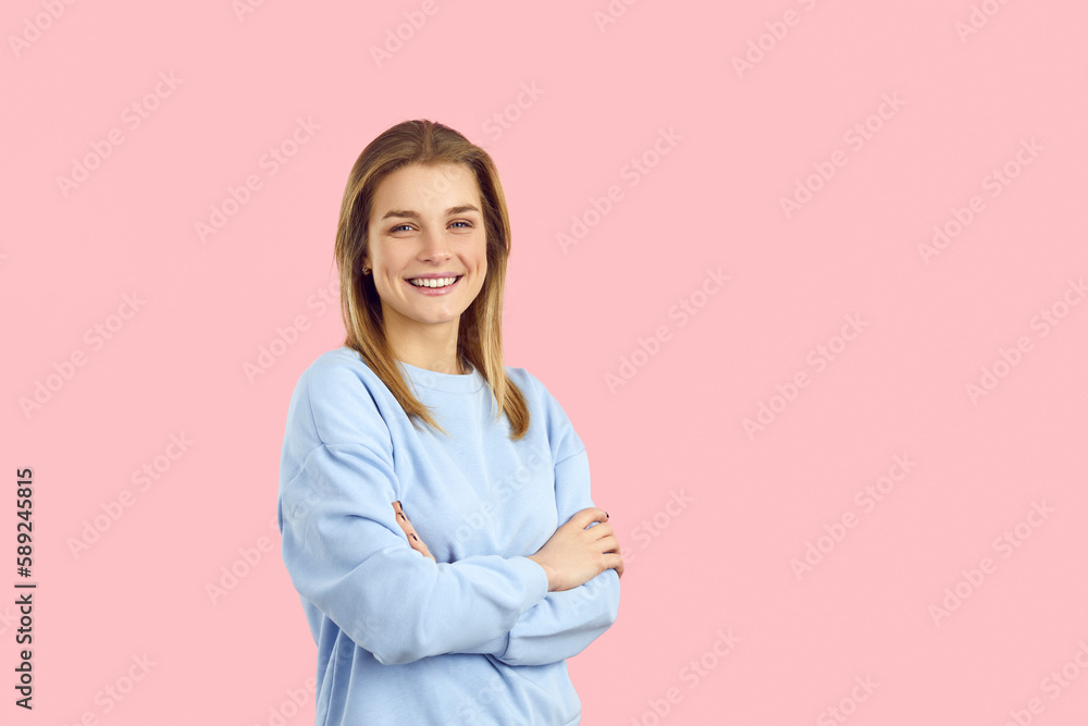Happy smiling young Caucasian woman or teenage girl in sweat shirt with cheerful positive face expression posing isolated on solid pink colour background with blank marketing text copyspace right side Happy smiling young Caucasian woman or teenage girl in sweat shirt with cheerful positive face expression posing isolated on solid pink colour background with blank marketing text copyspace right side