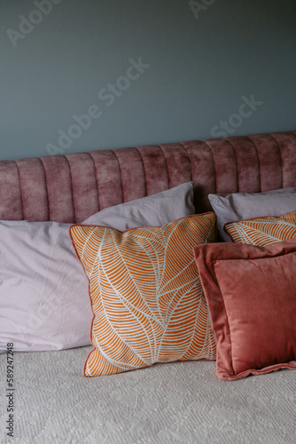 colourful fabric pillows on bed in a bedroom