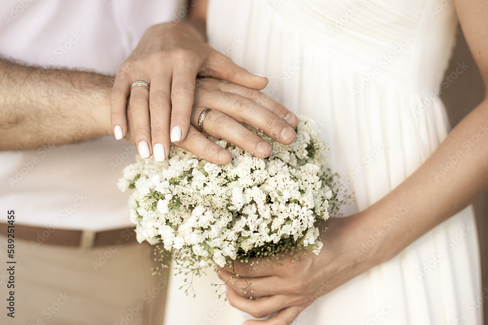 Newlyweds hands on wedding flowers Newlyweds hands on wedding flowers