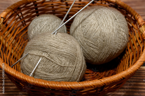 Gray balls of yarn in a basket. For knitting by hand on knitting needles. Close-up.