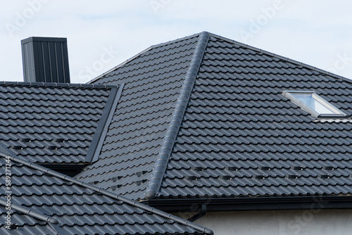 Roof of house with a skylight and chimney. Modern types of roofing materials