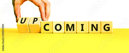 Coming or upcoming symbol. Concept words Coming and Upcoming on wooden cubes. Businessman hand. Beautiful yellow table white background. Business coming or upcoming concept. Copy space. photo