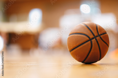 Close-up image of basketball ball over floor in the gym. Orange basketball ball on wooden parquet. © matimix