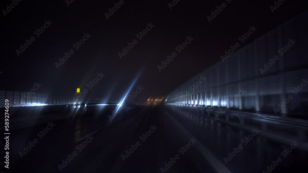 A view of the illuminated street at night from the driver's perspective A view of the illuminated street at night from the driver's perspective