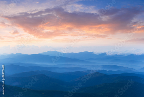 twilight mountain ridge silhouette in blue mist © Yuriy Kulik