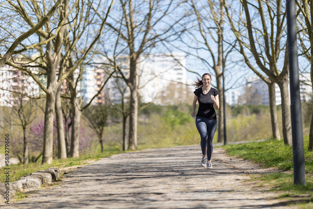 Adult sportive woman jogging in the autumn park Adult sportive woman jogging in the autumn park