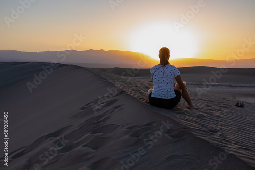 Silhouette of woman enjoying the sunrise with scenic view on Mesquite Flat Sand Dunes  Death Valley National Park  California  USA. Morning walk in Mojave desert with Amargosa Mountain Range in back.