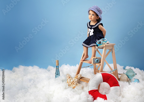 Photography Studio photo of Young child with lifebelt at blue background