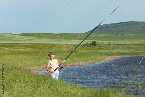 Hobby and leisure activities during summer holidays. Little Caucasian boy at fishing during the summer holidays