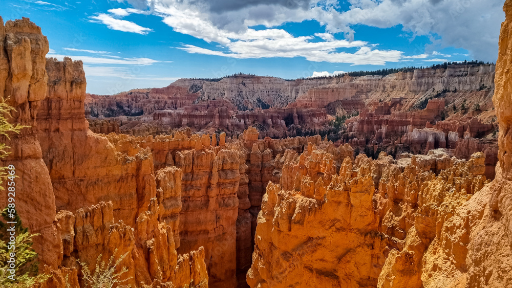 Scenic aerial view of massive hoodoo sandstone rock formation towers on Navajo trail in Bryce Canyon National Park, Utah, USA. Natural unique amphitheatre in summer. Dark clouds emerging to storm